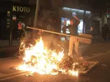 Un joven forma barricadas con vallas y contenedores ardiendo durante los incidentes por el desalojo de Can Vies, en Barcelona.