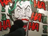 Dos visitantes del Salón del Cómic de Barcelona se abrazan ante un muro dedicado al Joker con motivo del 75º aniversario de este villano de Batman.