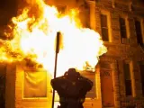 Bomberos acuden a extinguir las llamas en un edificio durante los disturbios provocados durante una protesta contra la muerte de Freddie Gray en Baltimore (Estados Unidos). Incendios, saqueos de tiendas y altercados con la Policía sumieron hoy a Baltimore en el caos.