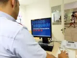 Un agente de los Mossos d'Esquadra consulta un ordenador en una comisaría.