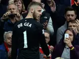 El portero David de Gea se retira lesionado durante el partido entre el Manchester United y el Arsenal en Old Trafford.