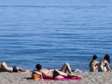 Un grupo de personas disfruta del buen tiempo en la playa.