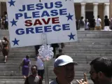 Un hombre sostiene una pancarta en la que se lee: "Jesús, por favor salva a Grecia", en la plaza Syntagma de Atenas, Grecia, en la mañana del lunes 15 de junio de 2015.