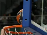 Un balón de baloncesto, en el momento de entrar en la canasta.