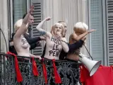 Activistas de organización feminista radical Femen son evacuadas por agentes de seguridad mientras protestan, a pecho descubierto y con el eslogan: Le Pen TOP fascist, desde un balcón durante la marcha por el Primero de Mayo organizada por el ultraderechista Frente Nacional (FN) en París (Francia).