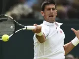 El tenista serbio Novak Djokovic devuelve la bola al finlandés Jarkko Nieminem en su partido de segunda ronda del torneo de tenis de Wimbledon.