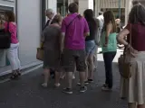 Ciudadanos atenienses aguardan una cola ante un cajero del Banco Nacional de Grecia.