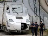 Efectivos de la policía custodian la locomotora del tren Alvia que descarriló en las inmediaciones de Santiago.