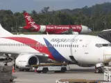 Un avión de Malaysia Airlines, y otro de AirAsia en un aeropuerto.