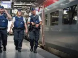 Varios agentes patrullan la vía donde se sitúa un tren Thalys.