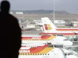 Un hombre observa varios aviones en el aeropuerto de Barajas.