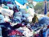Una joven rodeada de sacos llenos de jirones de tela, restos que las f&aacute;bricas venden a los residentes de la Colonia Sanjay, en Nueva Delhi.