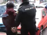Un agente de la Polic&iacute;a Nacional traslada detenido a uno de los integrantes del grupo anarquista desarticulado en Madrid en noviembre de 2015.