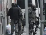 Agentes de policía antidisturbios permanecen en guardia en el distrito de Molenbeek en Bruselas (Bélgica), durante la operación dirigida a encontrar a Salah Abdeslam, sobre quien pesa una orden de arresto internacional.