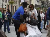 Mujer comprando un bolso en un 'top manta'.