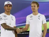 El piloto alemán de Mercedes Nico Rosberg (dcha) estrecha la mano a su compañero de equipo, el británico Lewis Hamilton, antes de una rueda de prensa.