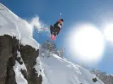Un esquiador realiza un salto en una ladera nevada.