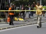 Miembros de los servicios de emergencia inspeccionan el lugar donde se ha producido varias explosiones cerca de un centro comercial en Yakarta (Indonesia). Al menos siete personas han muerto tras un ataque con explosivos.