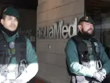 Agentes del instituto armado se encuentran en la puerta de la empresa Acuamed, en la calle de Albasanz de Madrid, para controlar los accesos.
