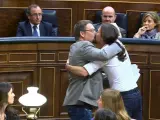 El líder de Podemos, Pablo Iglesias, y el de En Comú Podem, Xavier Doménech, celebrando su estreno en la tribuna de oradores de la Cámara Baja con un efusivo abrazo y un beso en los labios.