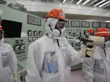 Un grupo de trabajadores de la empresa TEPCO, propietaria de Fukushima, comprueba la radiactividad de la planta nuclear en una de las salas de control de un reactor de la central.