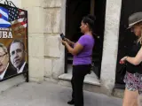 Dos turistas toman fotos de una imagen de los presidentes de Estados Unidos, Barack Obama y Cuba, Raúl Castro en La Habana.
