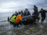 Migrantes y refugiados llegan en una embarcación a la isla griega de Lesbos.