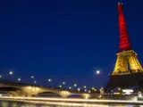 Vista de la torre Eiffel iluminada con los colores de la bandera nacional belga, en París (Francia), en honor a las víctimas de los ataques en Bruselas.
