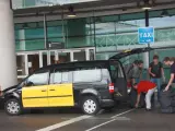 Un taxi de Barcelona recoge a unos turistas en el aeropuerto del Prat.