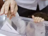 Un padre empuja el voto con el dedo de su pequeña hija en el colegio electoral del Instituto Santa Teresa de Jesus, durante las elecciones generales de 2015.