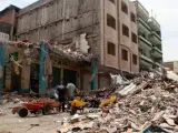 Un grupo de personas permanece frente a negocios colapsados en la zona céntrica de Manta (Ecuador).