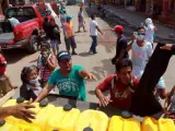 Un grupo de personas espera recibir insumos y agua de un camión con ayuda en Manta (Ecuador).