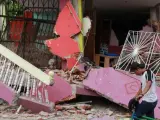 Un joven camina frente a una casa destruida, en el centro de Manta, por el terremoto que sacudió la zona.