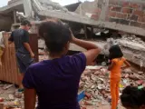 Una familia llega a una casa colapsada por el terremoto en la ciudad de Manta, Ecuador.