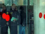 Un encapuchado, presumiblemente uno de los mossos imputados en el 'caso Raval', entra en la Ciudad de la Justicia de Barcelona.