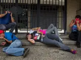 Un grupo manifestantes cubre sus rostros luego de recibir gases lacrimógenos lanzados por miembros de la Policía Nacional Bolivariana (PNB) durante una protesta en Caracas (Venezuela).