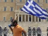 Un manifestante corre ante el Parlamento griego.