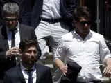 El jugador del FC Barcelona Lionel Messi (c), junto a su padre, Jorge Horacio Messi (detrás), y su hermano Rodrigo Messi, sale de la Audiencia de Barcelona.