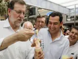 Mariano Rajoy, junto al líder del PP-A, Juanma Moreno, y Rafael Hernando (detrás), se toma un helado frente al Ayuntamiento de Adra (Almería).