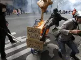Vista de un carrito ardiendo con carteles que rezan 'Ey, Valls ¿hace calor?' durante la manifestación contra la reforma laboral del Gobierno, en París (Francia).