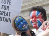 Una pareja con la cara pintada de las banderas del Reino Unido y la UE sostiene una pancarta en apoyo a la permanencia del país en la Unión Europea.