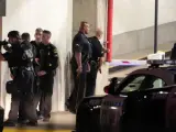 Varios policías se protegen, en un aparcamiento de Dallas (EE UU), de un tiroteo en el que han muerto al menos cinco agentes por los disparos de varios francotiradores.