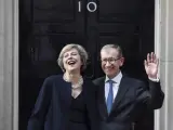 La nueva primera ministra británica, Theresa May (i), y su marido Philip (d), saludan a los medios .