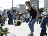 Una madre con su hijo dejan unas flores en memoria de las víctimas de la masacre de Niza, delante de la embajada de Francia en Moscú.
