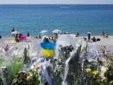 Flores y velas recuerdan a las víctimas en el paseo de los Ingleses, mientras turistas y vecinos de la ciudad disfrutan de un día de playa cinco días después del atentado de Niza que dejó 84 víctimas mortales y más de 300 heridos, en Niza, Francia.