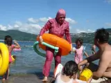 Una mujer usa un burkini en la costa.