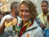 La nadadora Mireia Belmonte, posa con las medallas de oro en 200 mariposa y bronce en 400 estilos, a su llegada al aeropuerto de El Prat.