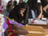 Una mujer permanece junto al féretro de su familiar en el funeral de Estado en Amatrice.