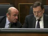 El ministro de Economía, Luis de Guindos, junto al presidente del Gobierno, Mariano Rajoy, en el Congreso.