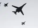 Uno de los dos bombarderos B-1B estadounidenses sobrevuela la base aérea de Osan flanqueado por cazas F-15K surcoreanos.